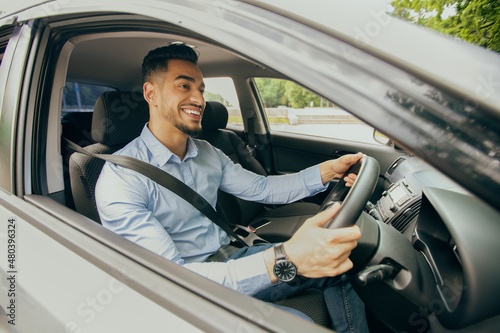 Positive middle-eastern guy going to office, driving car