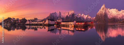 Fishing village near snowy mountains at sundown