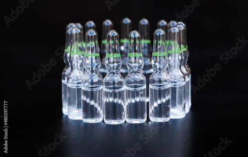 Small glass ampoules with medicine on a black background.