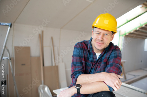 man on building site with yellow helmet works in drywall construction