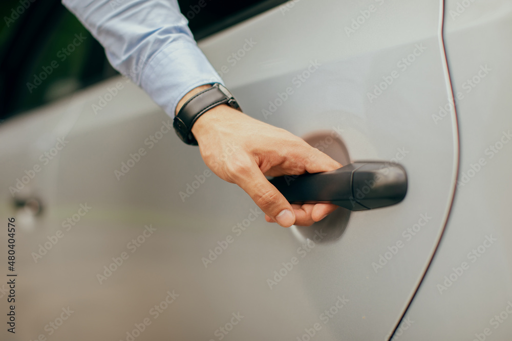 Man hand opening car back door, closeup photo