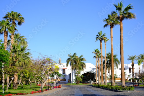 EGYPT Sharm el Sheikh. The tourists are on vacation at luxury hotel Savoy hotel main building surrounded by palm trees.Sunny day, blue sky.Touristic summer luxury vocation concept.