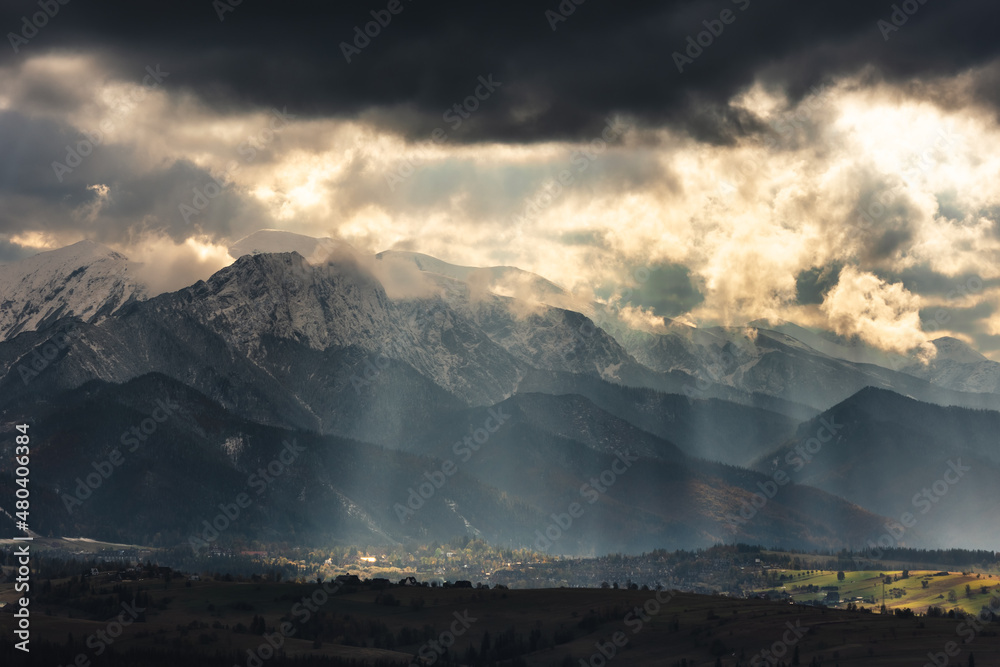 Tatra Mountains seen on a cloudy day. The shining light between the clouds creates an interesting atmosphere in the photo.