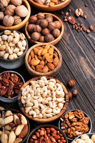 Nuts in assortment, Walnuts, pecans, almonds and other. Healthy food snack mix on wooden table background, top view