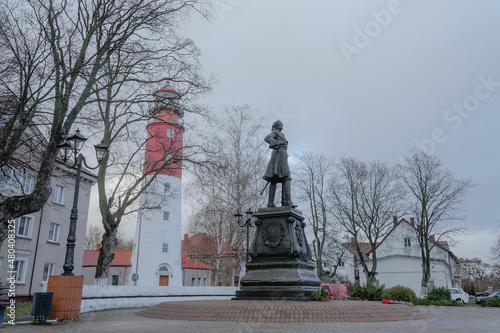 monument to Peter the Great, in the background a red lighthouse, spring day walk around the city