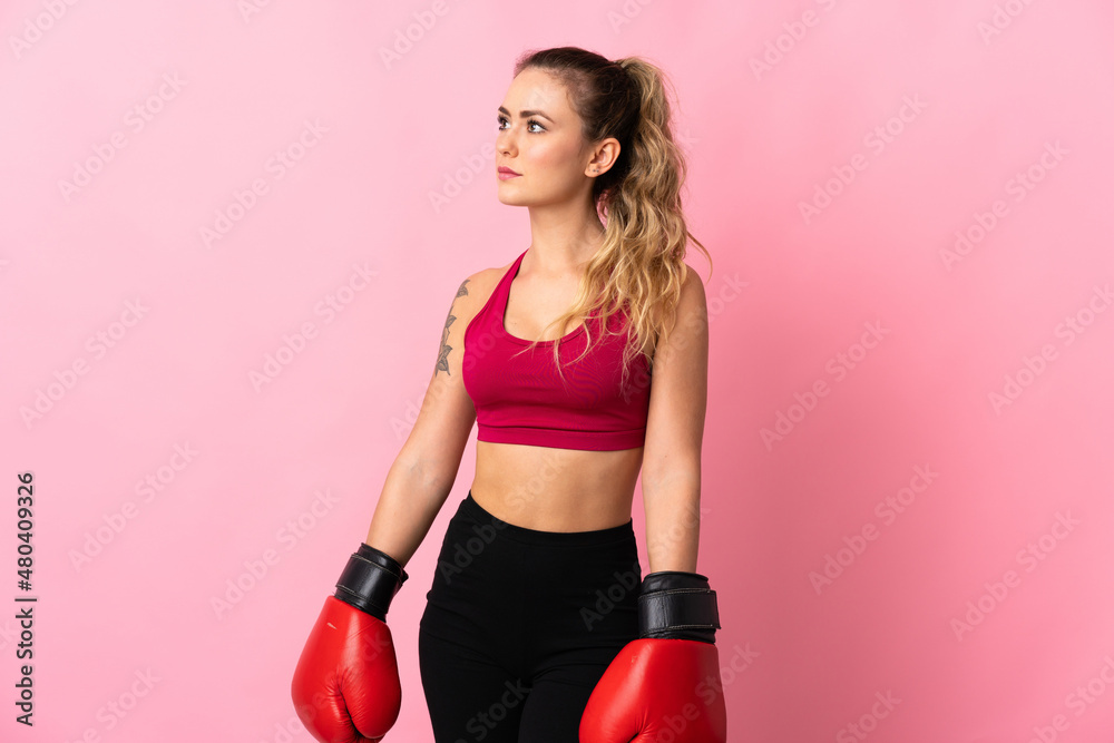Young Brazilian woman isolated on pink background with boxing gloves