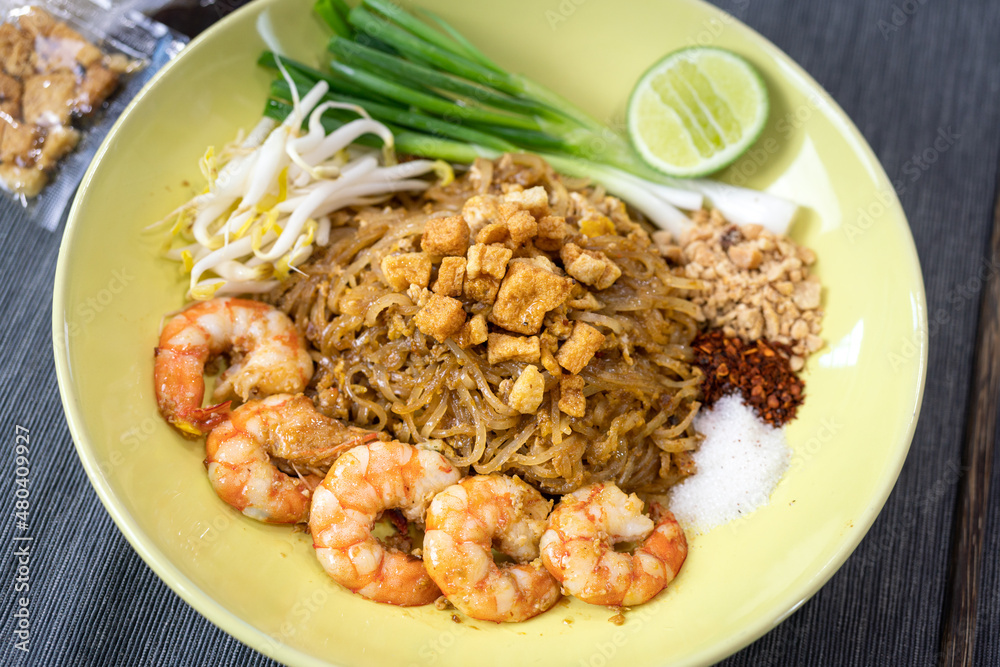 Prawn Pad Thai one of most famous thai food menu which is served in yellow ceramic plate. Food object photo, close-up and selective focus. Prawn Pad Thai one of most famous thai food menu which is served in yellow ceramic plate. Food object photo, close-up and selective focus.