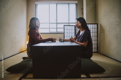 Mother and daughter lifestyle moments at home. Japanese family having a conversation in a traditional apartment