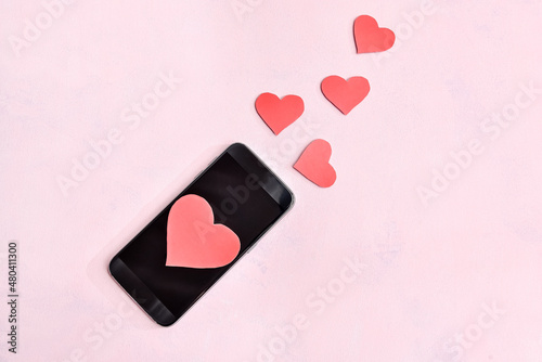 A smartphone with a blank screen and red hearts. The concept of love messages.