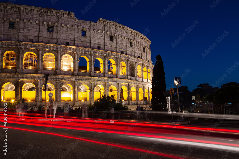 Night view of the famous Colosseum (Flavian Amphitheatre) in Rome, Italy. With trails of traffic lights.