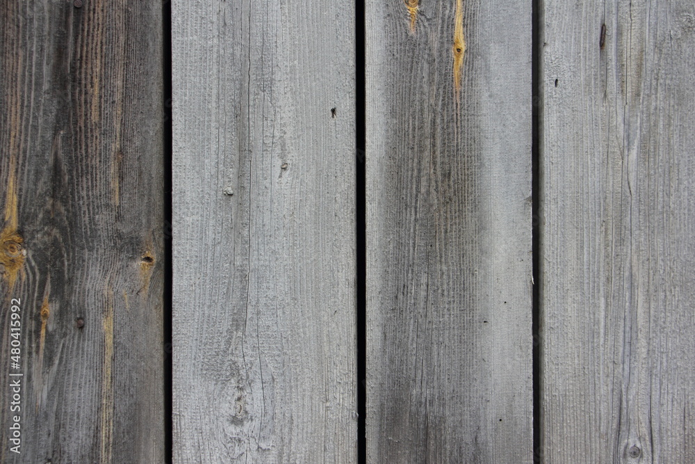Old dry gray wooden wall surface of a rural barn with weathered vertical boards close-up - vintage rustic background texture Old dry gray wooden wall surface of a rural barn with weathered vertical boards close-up - vintage rustic background texture