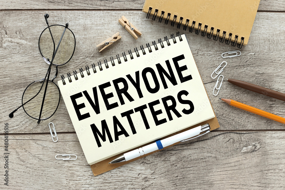 Everyone matters - text on open notepad on wooden table - obrazy, fototapety, plakaty 