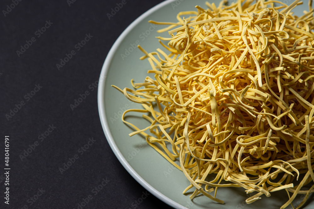 Egg noodles on a black background. Homemade traditional noodles on a plate. pasta