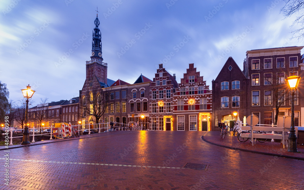 Fototapeta premium Beautiful old houses on the city embankment of Leiden at sunset.