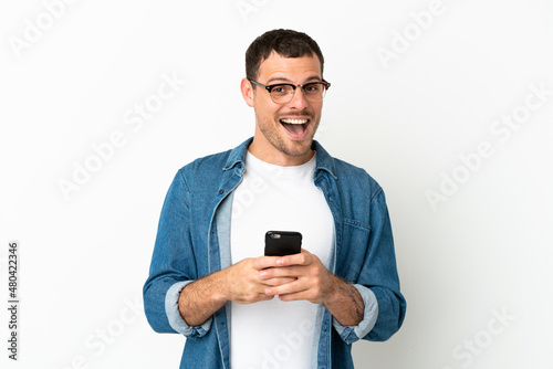 Brazilian man over isolated white background surprised and sending a message © luismolinero