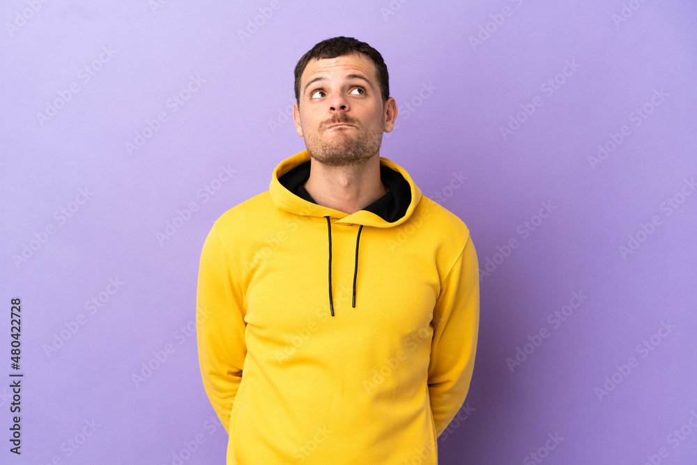 Brazilian man over isolated purple background and looking up Brazilian man over isolated purple background and looking up