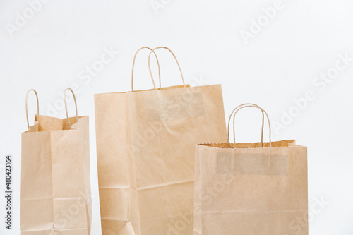 Three empty brown paper bags arranged in a composition over white background.