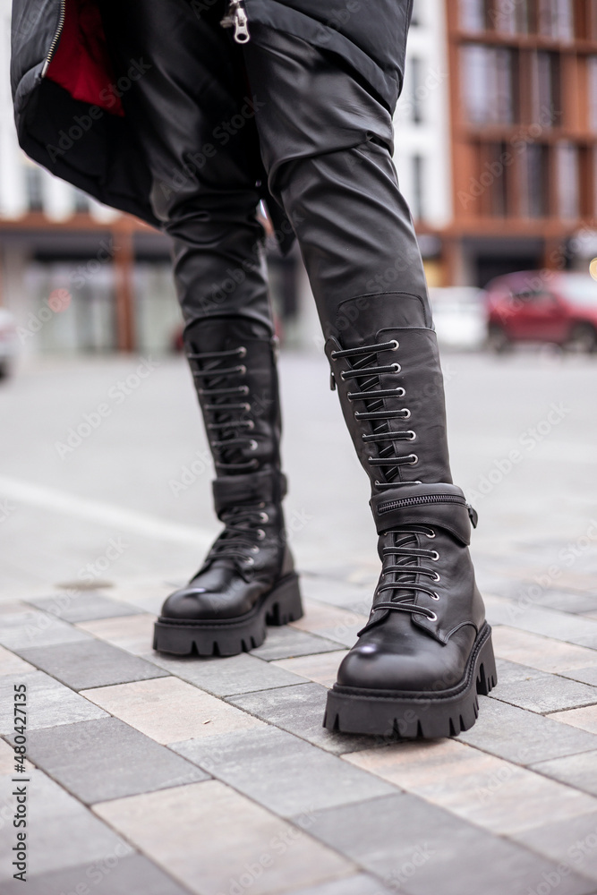 Naklejka premium Slender female legs close-up in genuine leather boots. New collection of women's spring shoes