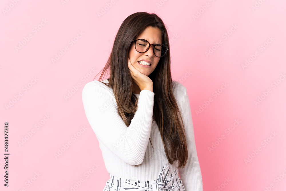 Young brazilian woman isolated on pink background with toothache Young brazilian woman isolated on pink background with toothache