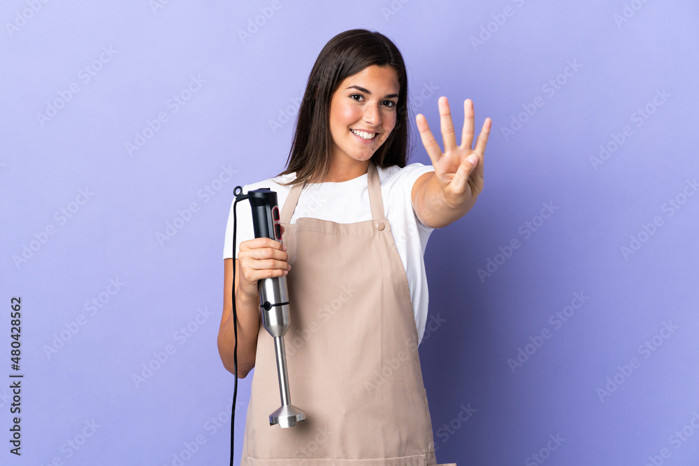 Brazilian woman using hand blender isolated on purple background happy and counting four with fingers Brazilian woman using hand blender isolated on purple background happy and counting four with fingers