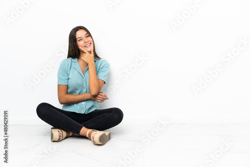 Teenager girl sitting on the floor smiling