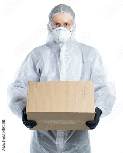 A man in a protective suit, mask and glasses holds a box. contactless, safe delivery. Covid-19, disease, epidemic. isolated