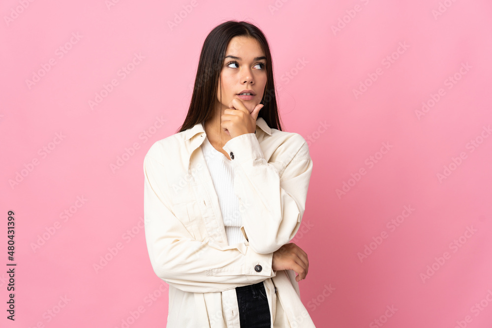 Teenager girl isolated on pink background thinking an idea while looking up Teenager girl isolated on pink background thinking an idea while looking up