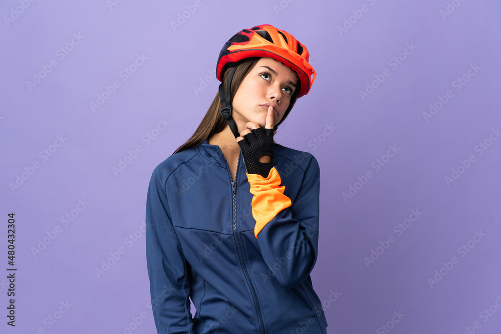 Teenager cyclist girl having doubts while looking up Teenager cyclist girl having doubts while looking up