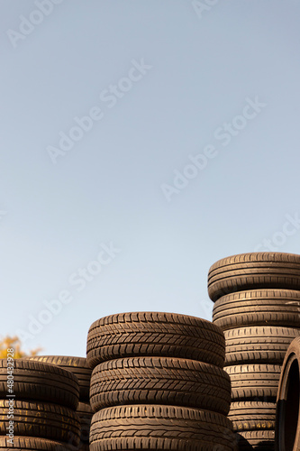 waste stacked old tires against the blue sky