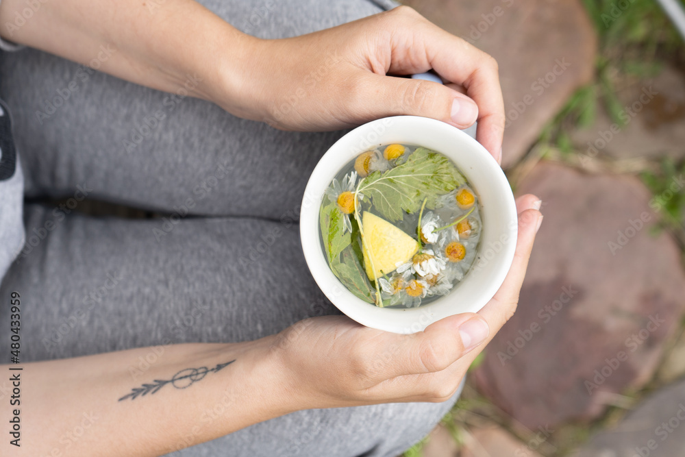 A woman holding herbal tea in a cup