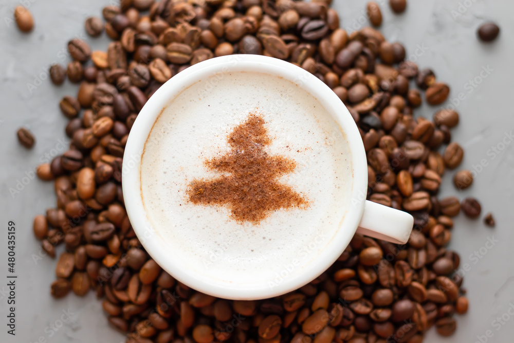 white cup of coffee cappuccino on a concrete background next to coffee beans white cup of coffee cappuccino on a concrete background next to coffee beans