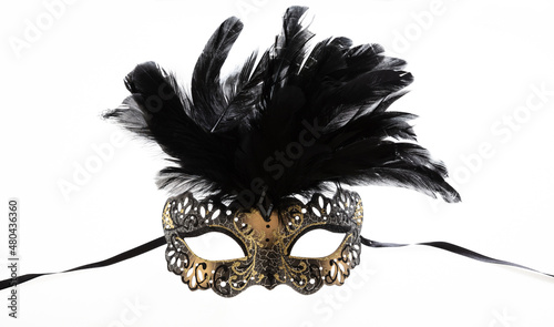 Carnival mask golden color with black feather decoration isolated on white background,