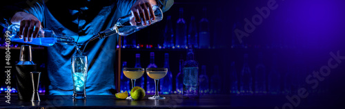 Bartender's hands serving cocktails on bar counter in a restaurant, pub. Mixed drinks. Alcoholic cooler beverage at nightclub on dark background photo