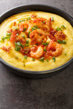 delicious fresh homemade cajun style shrimp and grits with cheddar closeup in the plate on the concrete table. Vertical