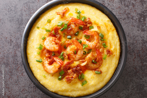 Bowl with fresh tasty shrimp and grits on a dark concrete background. American cuisine. Horizontal top view from above photo