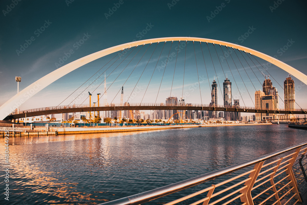 Naklejka premium DUBAI, UAE - FEBRUARY 2018: Colorful sunset over Dubai Downtown skyscrapers and the newly built Tolerance bridge as viewed from the Dubai water canal.