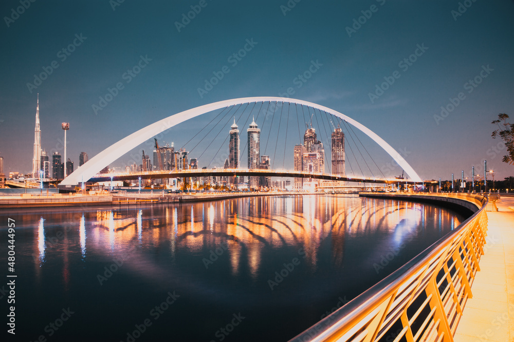 Obraz premium DUBAI, UAE - FEBRUARY 2018: Colorful sunset over Dubai Downtown skyscrapers and the newly built Tolerance bridge as viewed from the Dubai water canal.