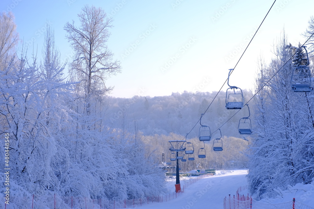 Obraz premium Snow-covered trees in hoarfrost at a ski resort, lift, funicular, ski lift 