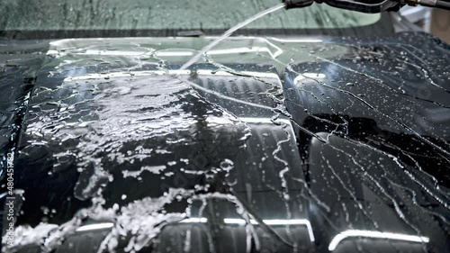 Checking after applying a layer of ceramic protective coating anti-rain on the car surface to prevent corrosion and oxidation, sun and water damage. Carwash or Car Detailing process photo