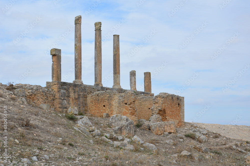 Ruins of  the ancient roman city of Dougga in modern Tunisia, Africa. Blue sky with clouds, white, grey and yellow stones, columns of Baal-Saturn pagan temple