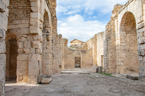 Baths of Licinius, Temple of Jupiter and some other ancient roman ruins of Dougga in Tunisia, Africa in the sunny afternoon. Blue sky with clouds, old yellow stones photo
