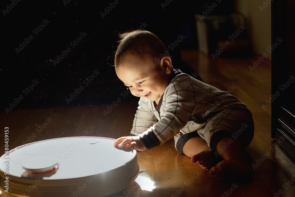 a child and a robot vacuum cleaner Stock Photo | Adobe Stock