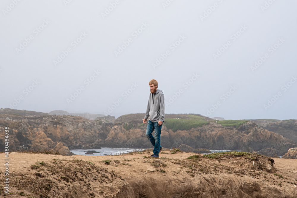 Man Hiking Through Tide Pools Along California Coast on a Cloudy Day at Fort Braggs