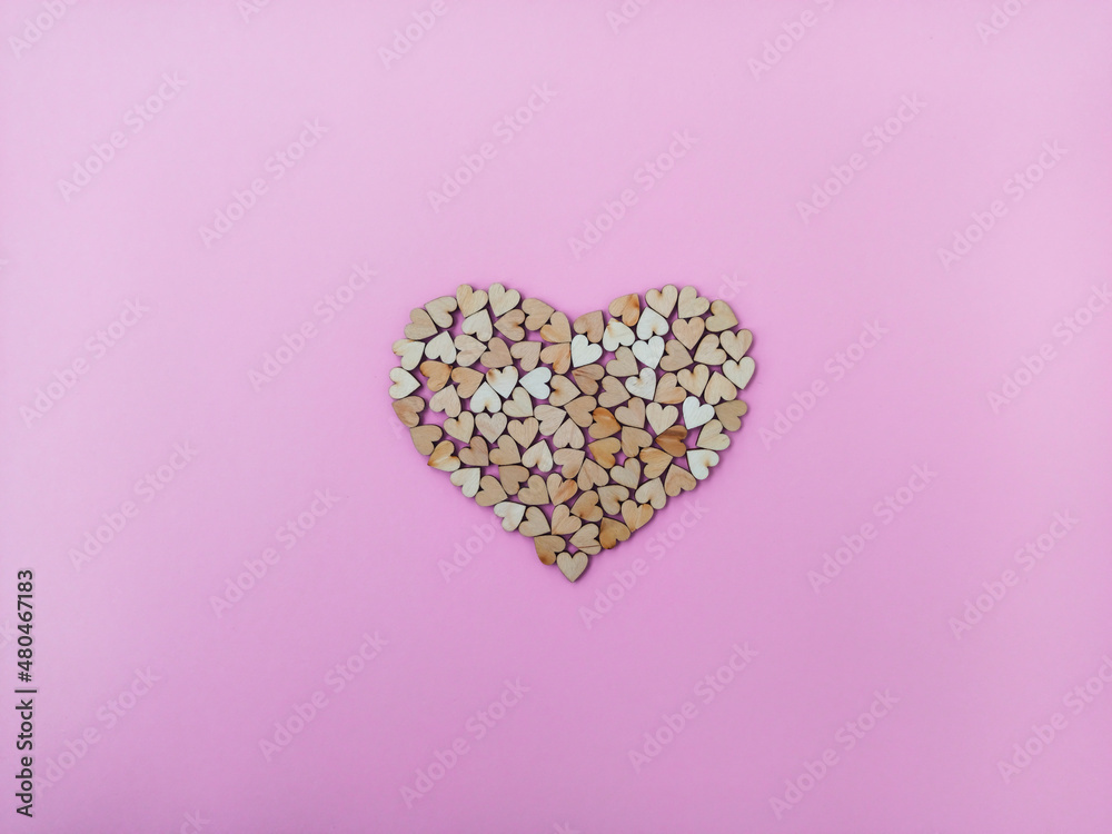 A big heart made of many small wooden hearts on a pink-purple background. Cute Valentine's Day card A big heart made of many small wooden hearts on a pink-purple background. Cute Valentine's Day card