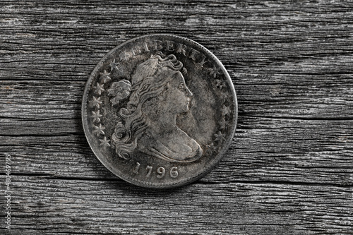 Close up of an antique silver coin from United States on aged wood