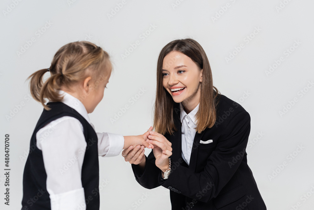 happy mother holding hands with disabled daughter isolated on grey. happy mother holding hands with disabled daughter isolated on grey.