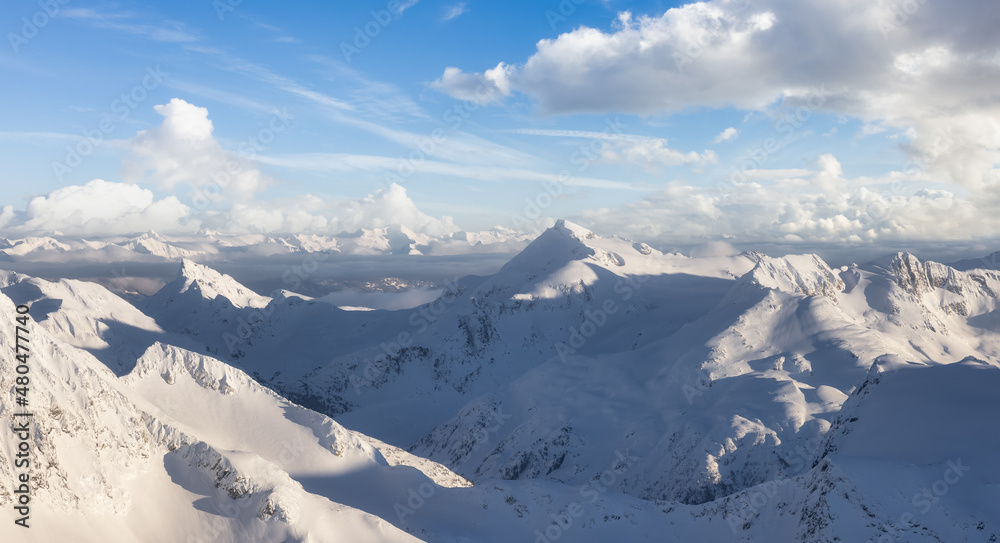 Fototapeta premium Aerial Panoramic View of Canadian Mountain covered in snow. Sunny winter season with cloudy sky art render. Located near Whistler, North of Vancouver, British Columbia, Canada. Nature Background