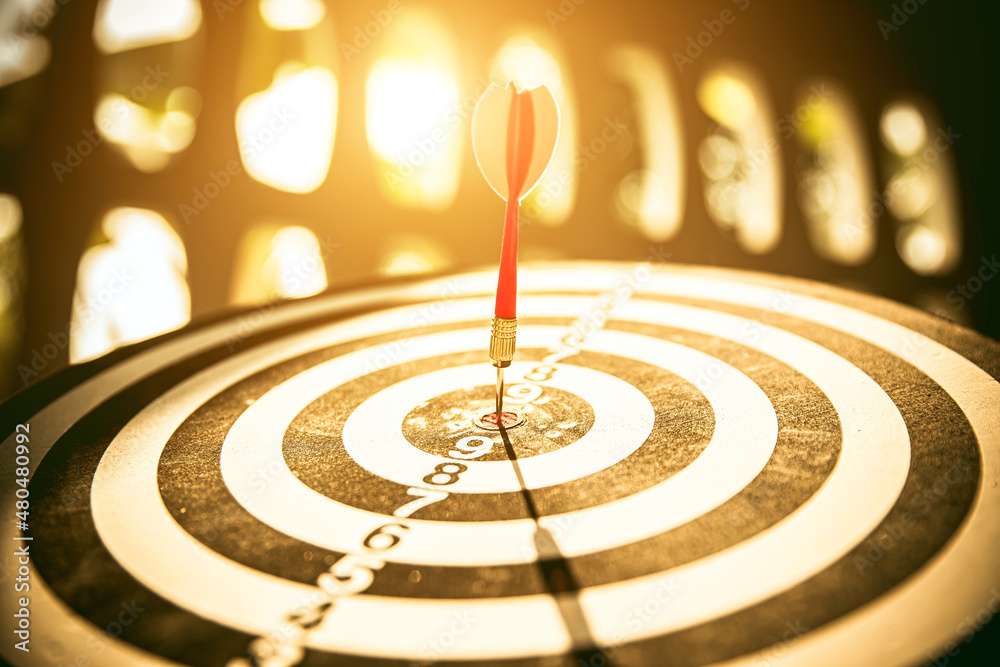 Bullseye or Bulls eye target or dartboard has dart arrow throw hitting the center of a shooting for financial business targeting planning and aim to winner goal of business concept. Bullseye or Bulls eye target or dartboard has dart arrow throw hitting the center of a shooting for financial business targeting planning and aim to winner goal of business concept.