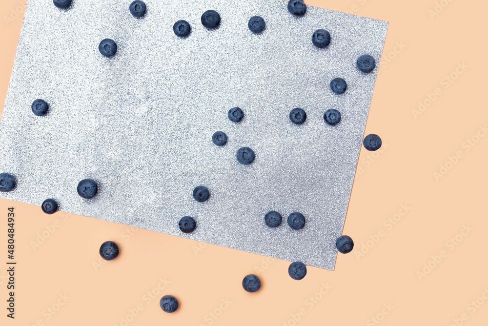 scattered blueberry berries on a beige and gray shiny background scattered blueberry berries on a beige and gray shiny background