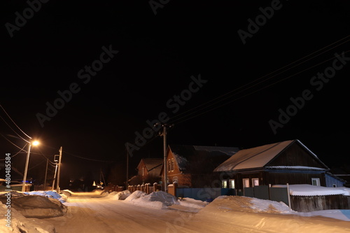 a snow-covered village street on a winter night